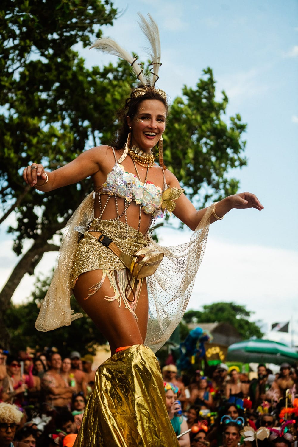 Juliane sorrindo em performance com figurino dourado